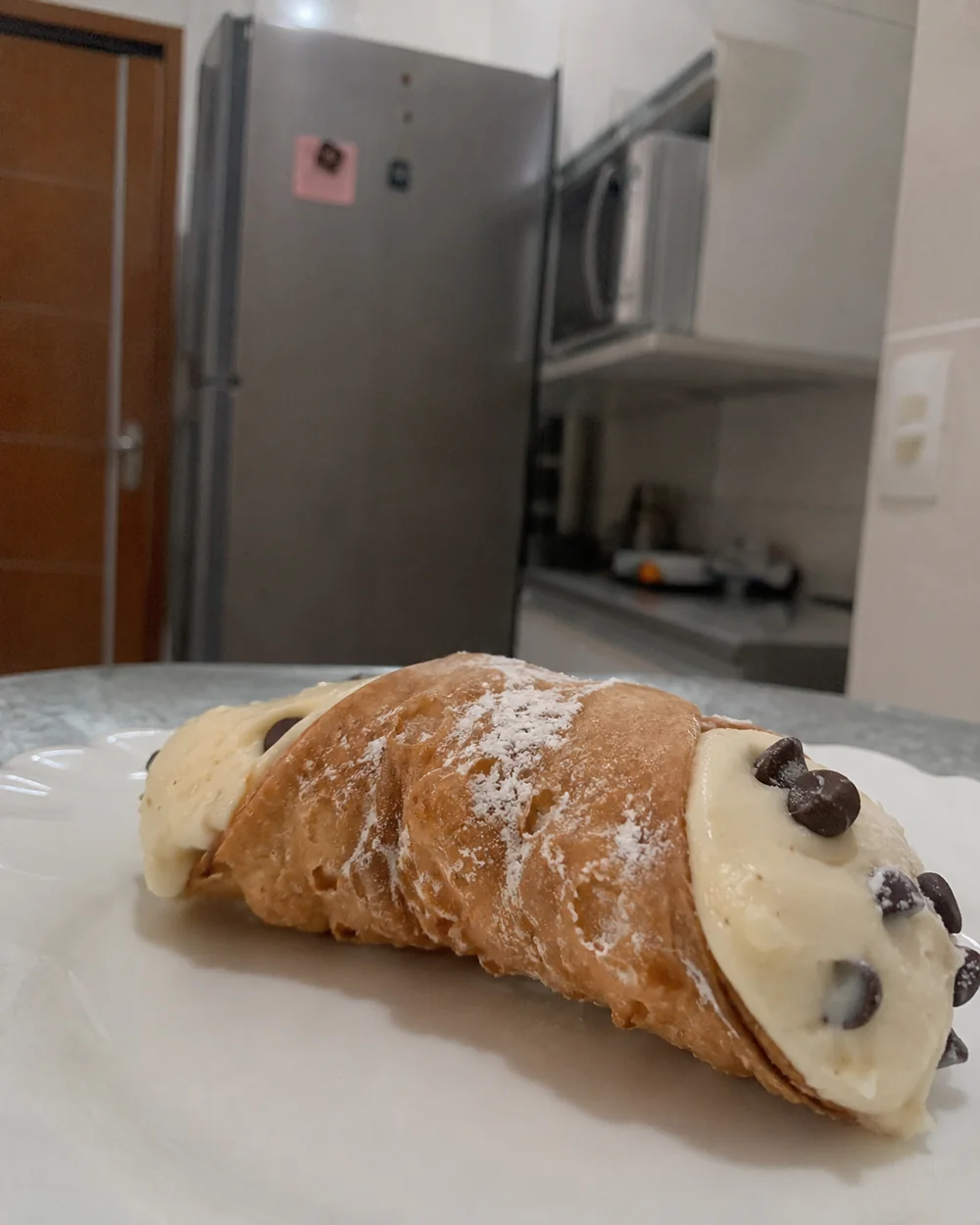 Cannoli italiano caseiro recheado com creme e gotas de chocolate