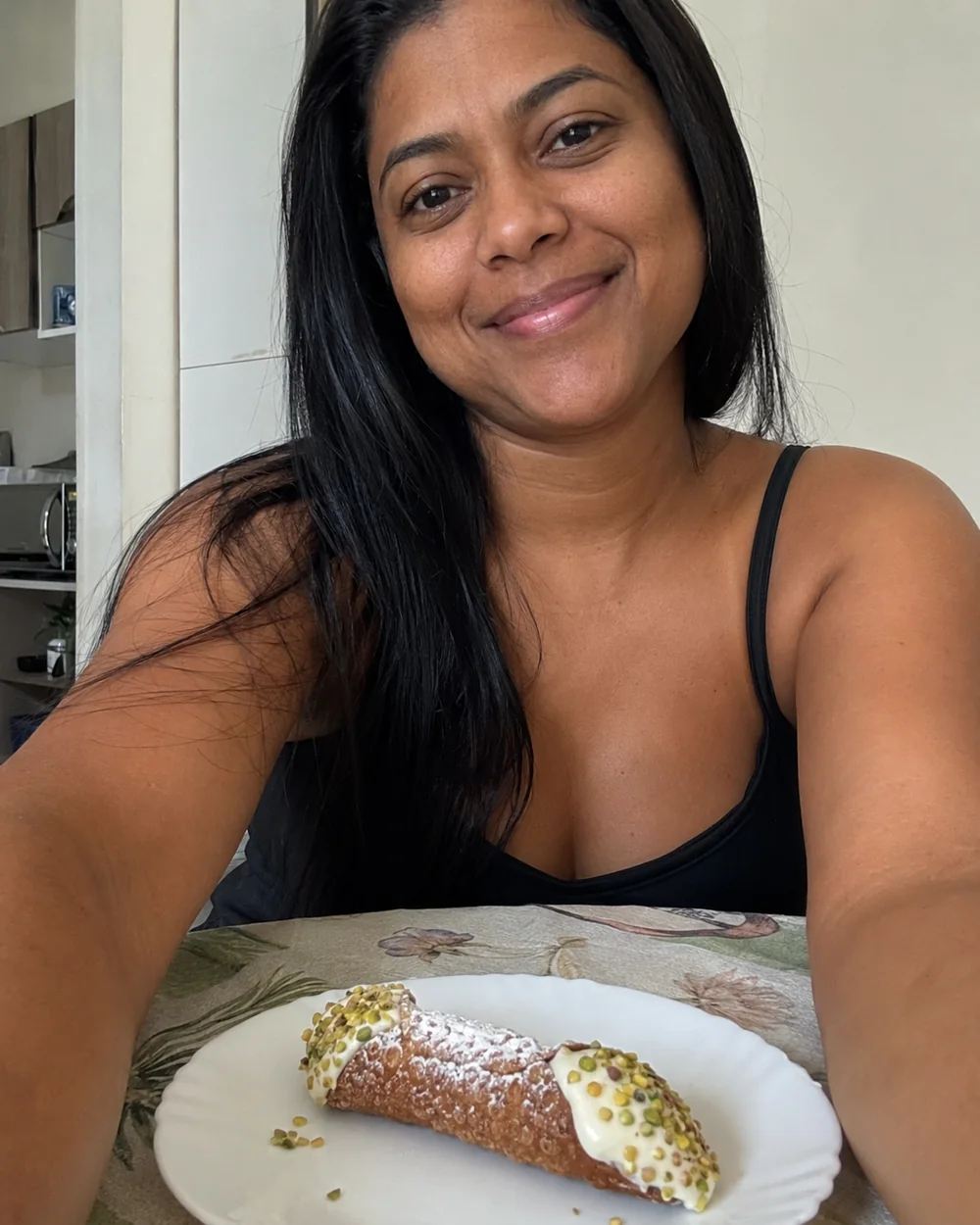 Cliente mostrando um cannoli siciliano caseiro com pistache