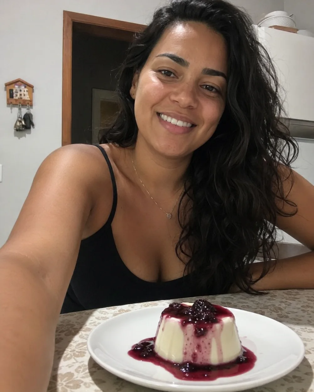 Cliente à mesa com panna cotta e calda de frutas vermelhas