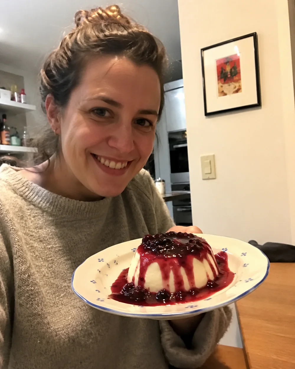 Cliente mostrando panna cotta com calda de frutas vermelhas