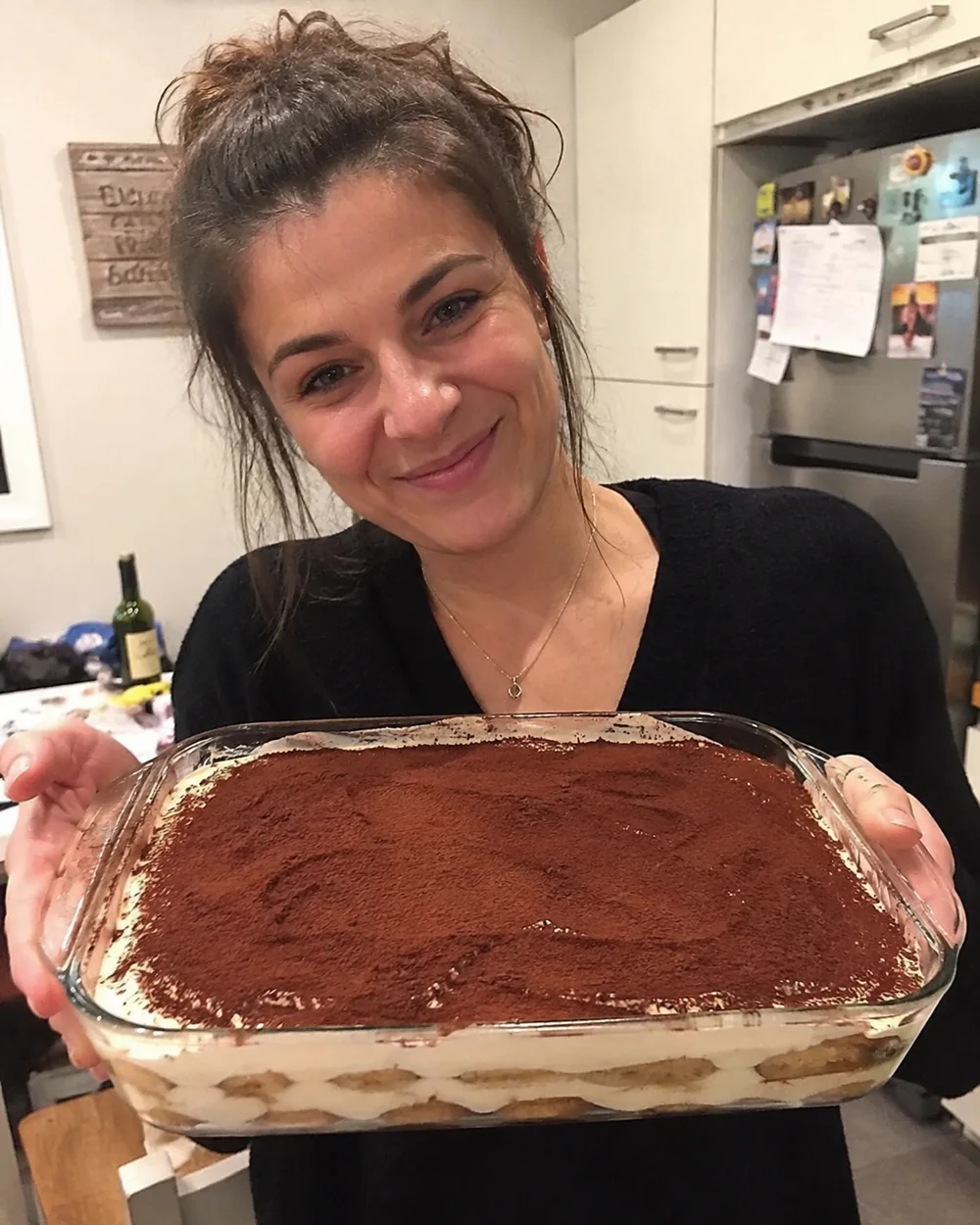 Cliente segurando uma travessa de tiramisù italiano caseiro